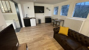 A modern apartment with a kitchen, dining area, and living room.