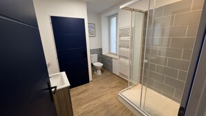 Ein modernes Badezimmer mit Dusche, Toilette und Waschbecken.
