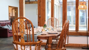 A dining table set with chairs, a bottle, and various dishes. - Beachside holiday home  (Padstow)