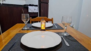 A dining table set with plates, cutlery, and glasses, with a decorative lantern in the center. - Seu aconchegante lar no centro carioca (Rio de Janeiro)