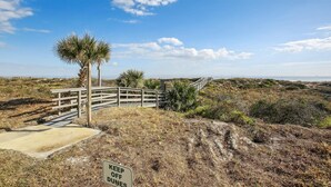A wooden boardwalk leading to a beach area with a 'KEEP OFF DUNES' sign. - Ocean View Condo at Sea Haven (St. Augustine)