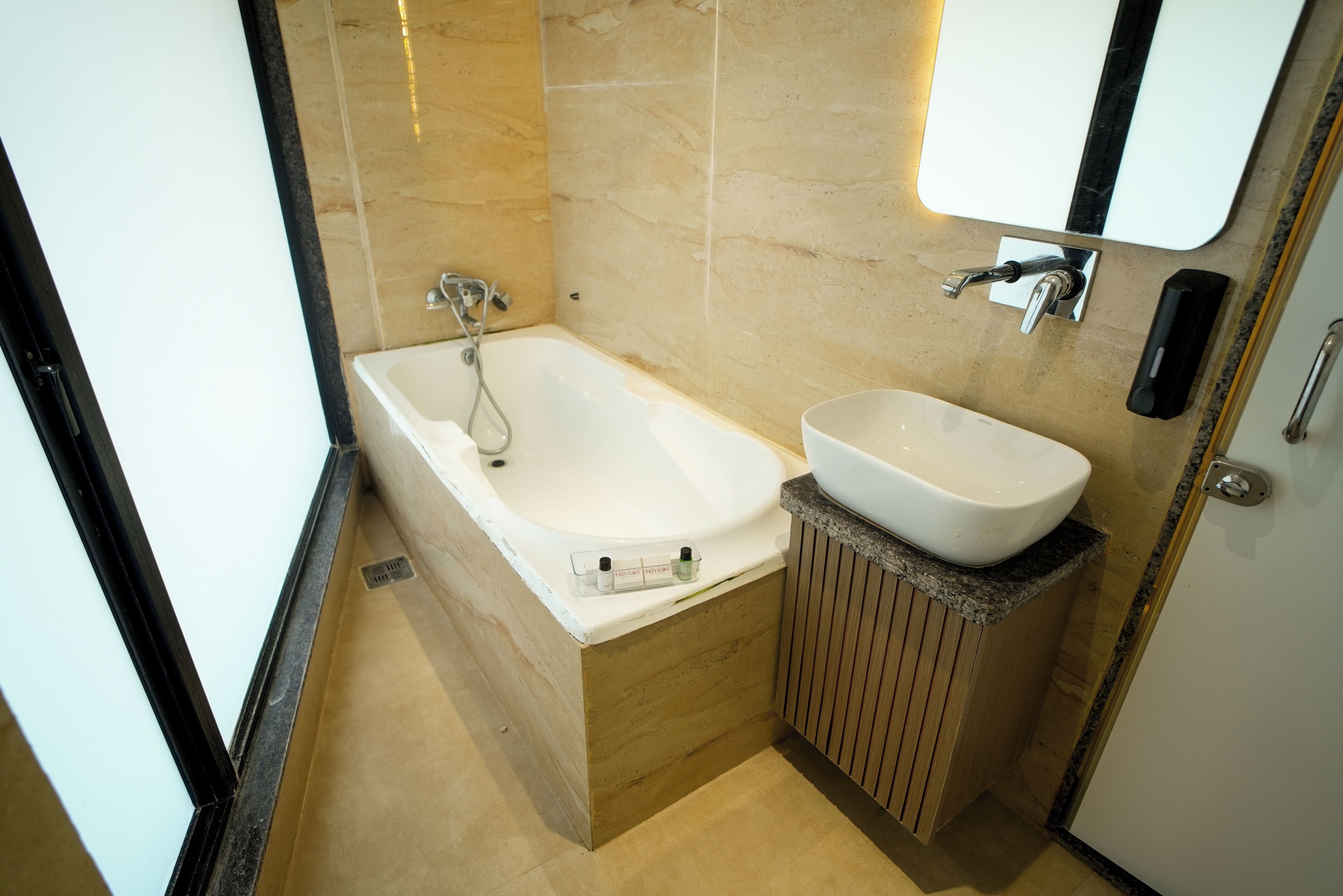 A bathroom with a bathtub, a sink, and a mirror.