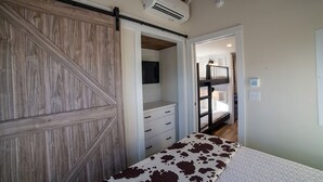 Ein Schlafzimmer mit Etagenbett, Kleiderschrank und Klimaanlage.