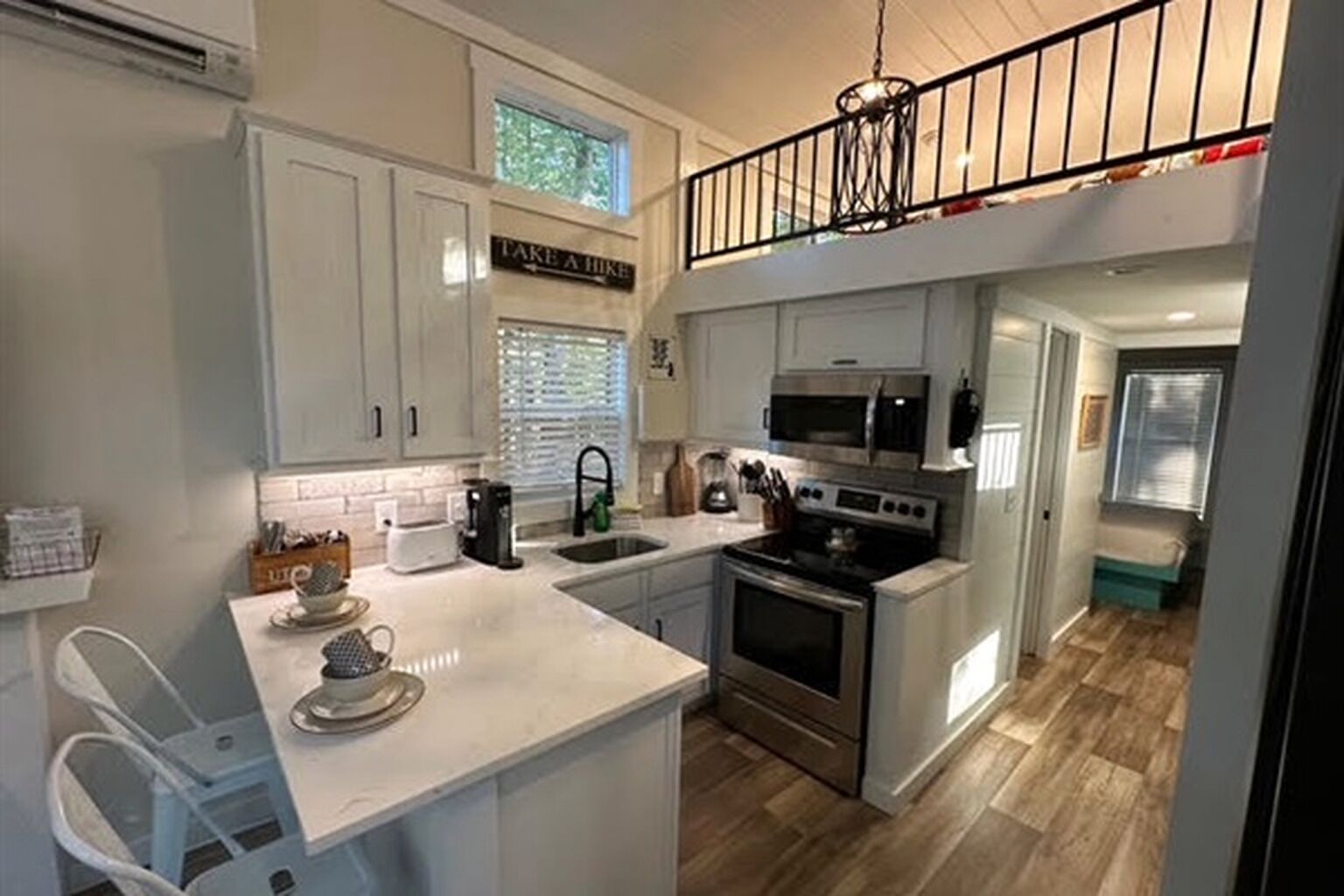 A kitchen with a central island, stainless steel appliances, and a sign that says 'TAKE A HIK'.