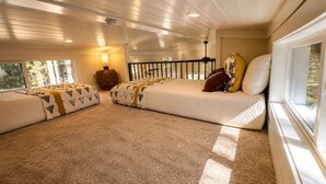 A room with a large bed, a window, and a ceiling fan.