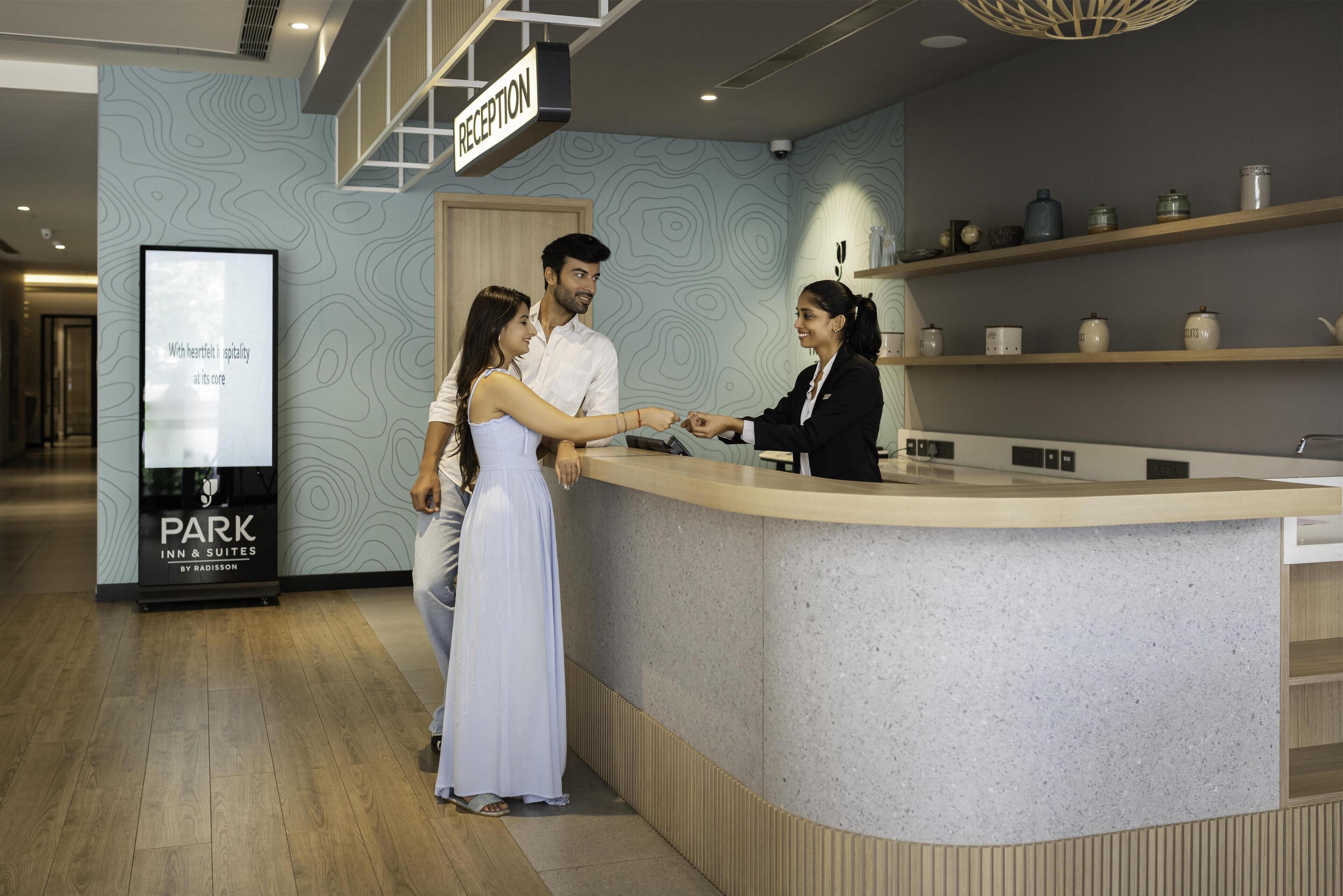 A reception area with a reception desk, a sign above it, and a poster on the wall.