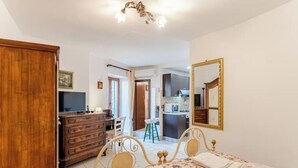 A bedroom with a bed, dresser, and a mirror. - Pearl of Vesuvius  (Napoli)