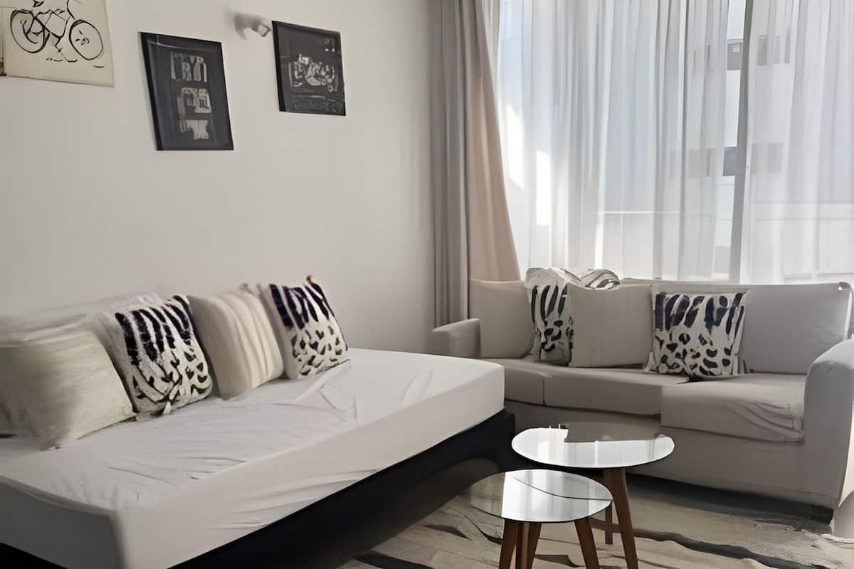 A modern living room with a sofa, a bed, and a coffee table.