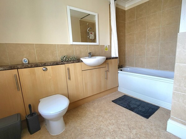 A bathroom with a toilet, sink, and bathtub.