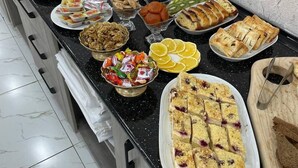 Ein Buffet mit verschiedenen Speisen, darunter Obst, Gebäck und Snacks.