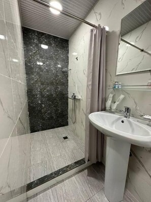 Habitación doble | Baño | Regadera, secadora de cabello, pantuflas, toallas 