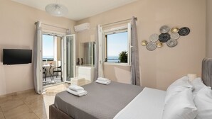 A bedroom with a bed, a TV, and a balcony with a view. - Villa Mediterranean View (Corfu)
