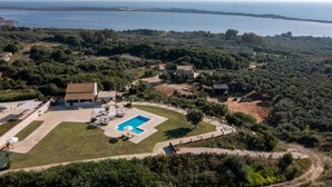 An aerial view of a property with a swimming pool, a large lawn, and a view of the sea. - Villa Mediterranean View (Corfu)
