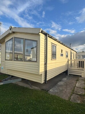 A single-story mobile home with a front porch, large windows, and a visible number 'N193' on the side. - Olivia Caravan Sleeps 6 With Wi-fi (Rhyl)