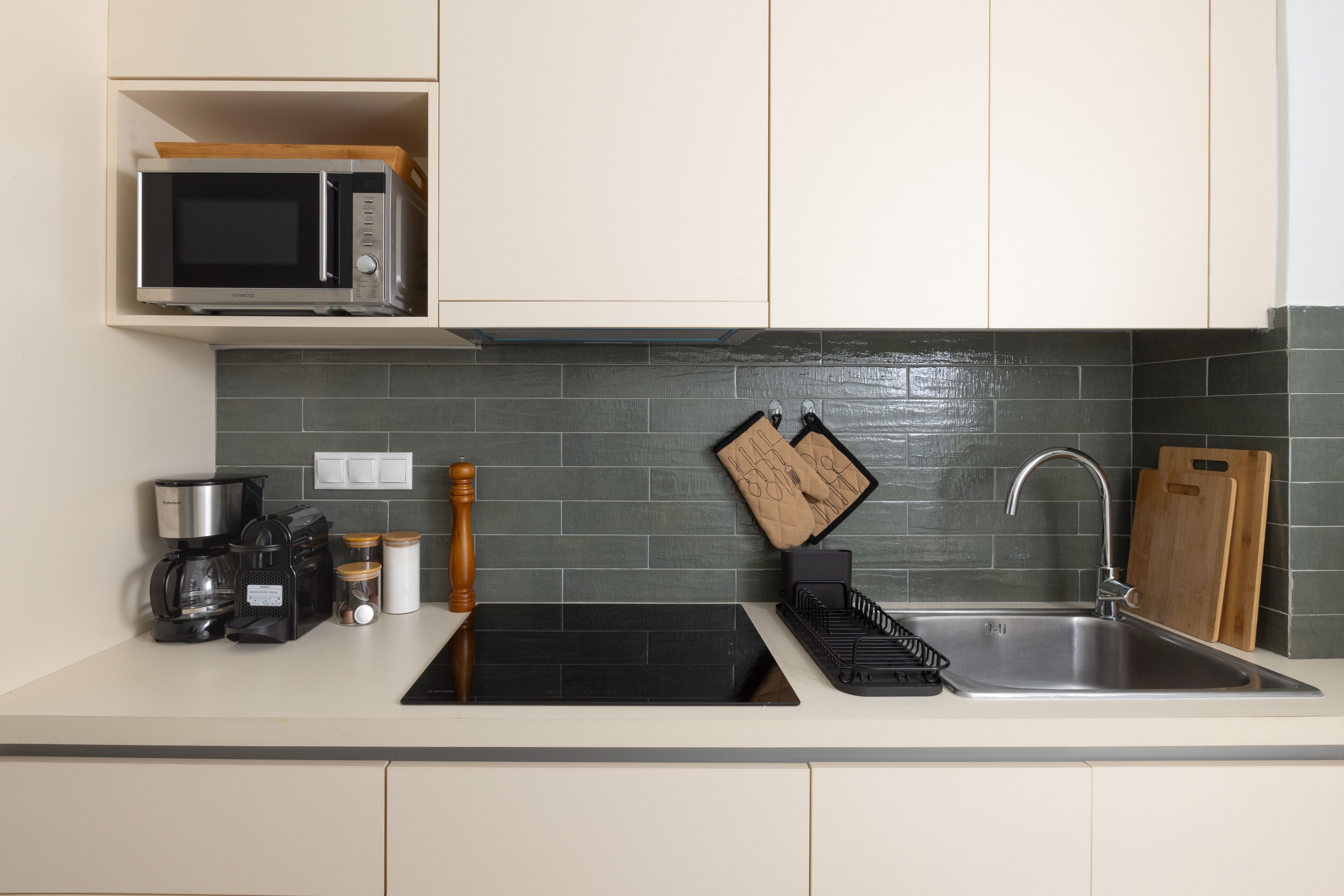 A modern kitchen with a microwave, coffee maker, and a sink.