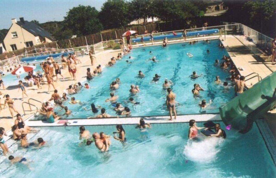 A swimming pool with multiple lanes, a diving board, and a lifeguard stand.