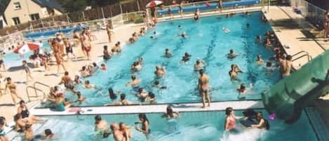 Piscina con varias pistas de natación, un trampolín y un puesto de socorrista.
