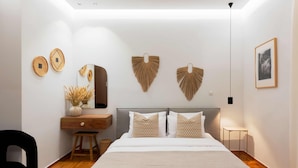 A bedroom with a bed, a desk, a chair, and decorative wall hangings. - Phaedrus Living Kolonaki Maple Residence (Athens)