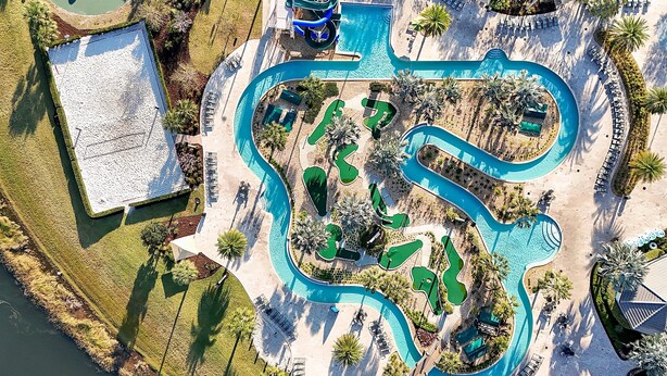 Eine Vogelperspektive zeigt ein Resort mit Schwimmbad, Golfplatz und Liegebereichen.