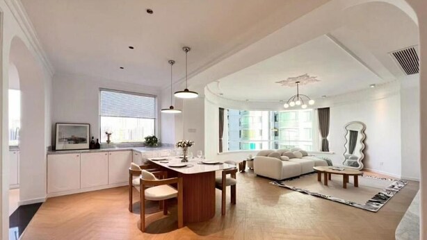 Eine moderne Küche mit Essbereich, ein Wohnzimmer mit Sofa und Couchtisch sowie ein großes Fenster für natürliches Licht.