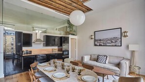 Um espaço moderno com área de refeições, cozinha e zona de estar.