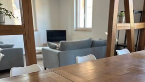 A dining area with a wooden table and white chairs.