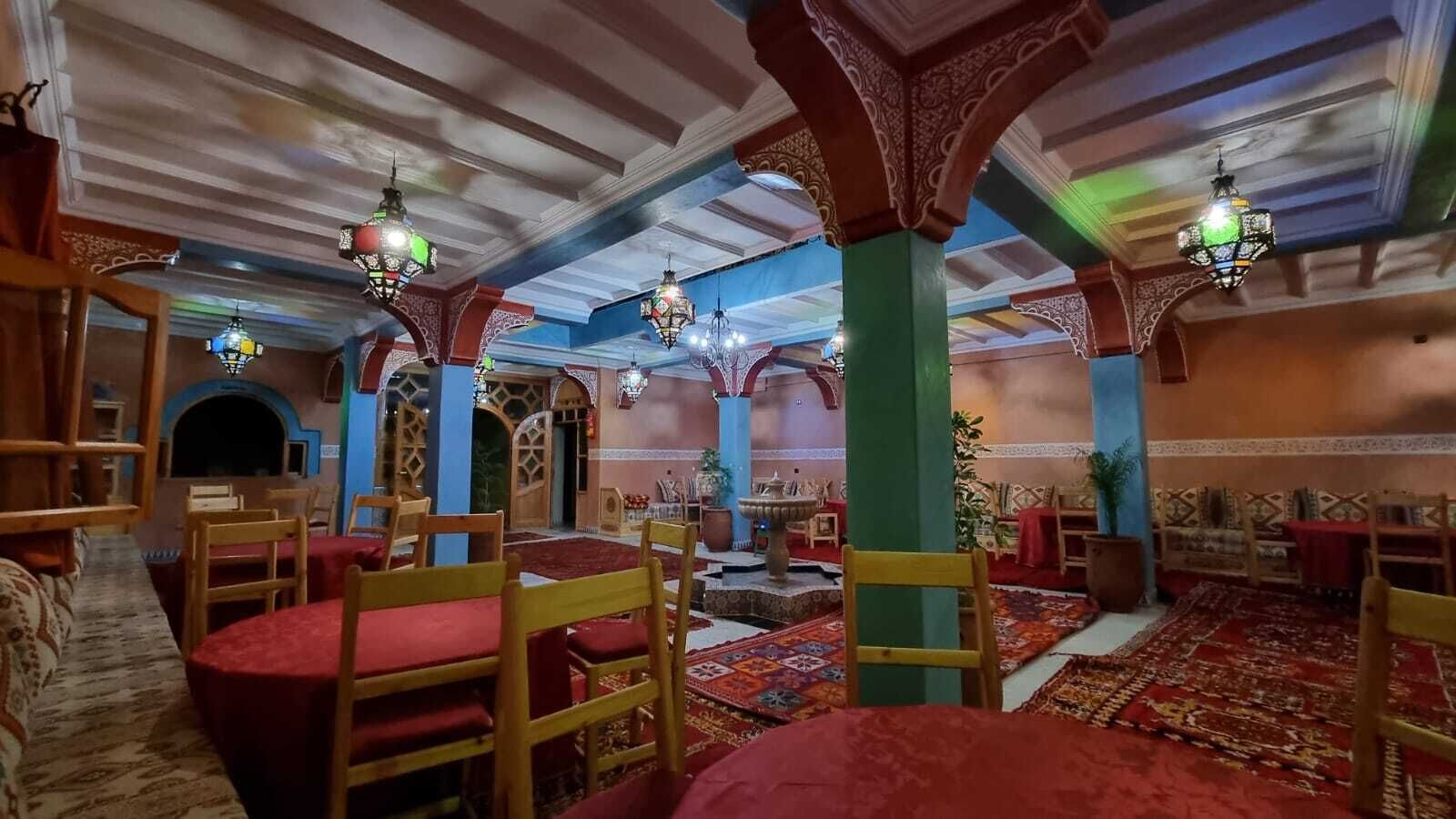 Ein traditionelles Interieur mit Holzmöbeln, gemusterten Teppichen und aufwendigen Deckenverzierungen.