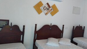 A room with three wooden beds, a white wall, and an air conditioning unit. - Recanto da Cleide (Paraty)