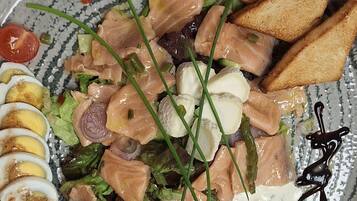 A plate with salmon, eggs, and vegetables.