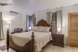 Une chambre bien rangée, avec un lit en bois, une table de chevet, une chaise et une armoire.
