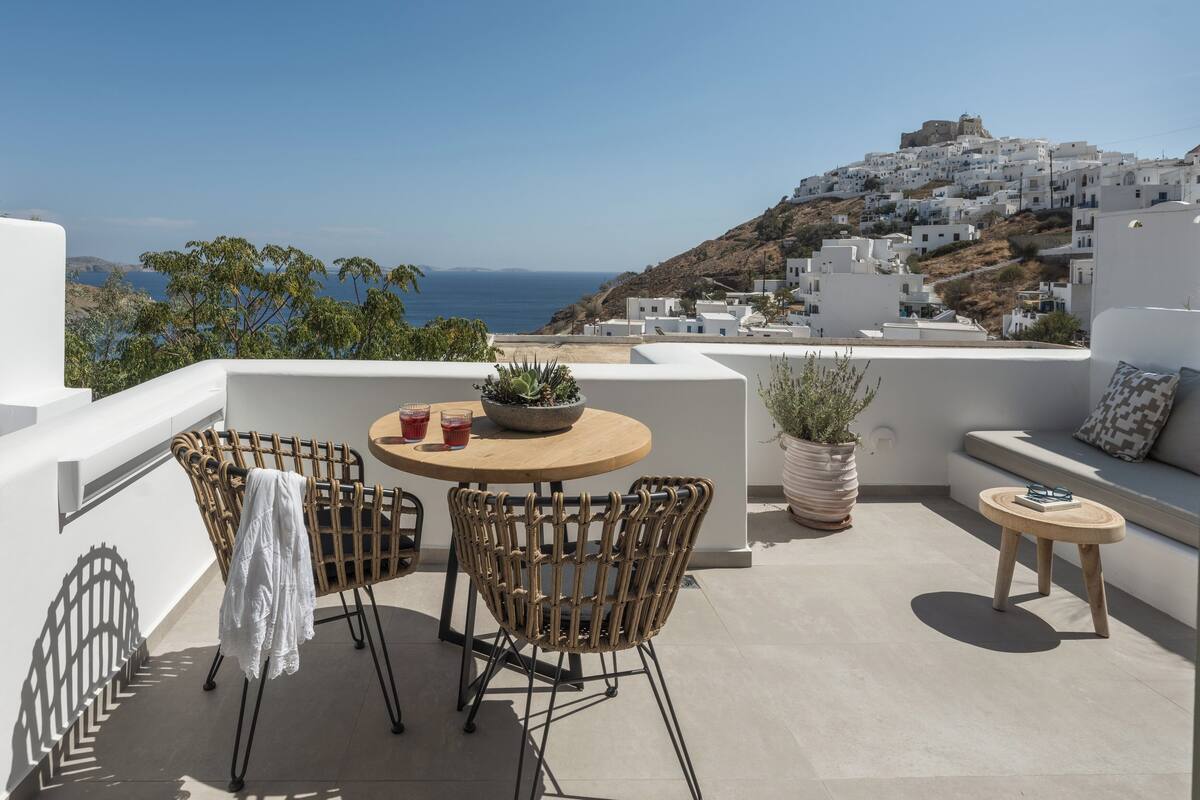 A terrace with wicker furniture, a round table, and a potted plant.