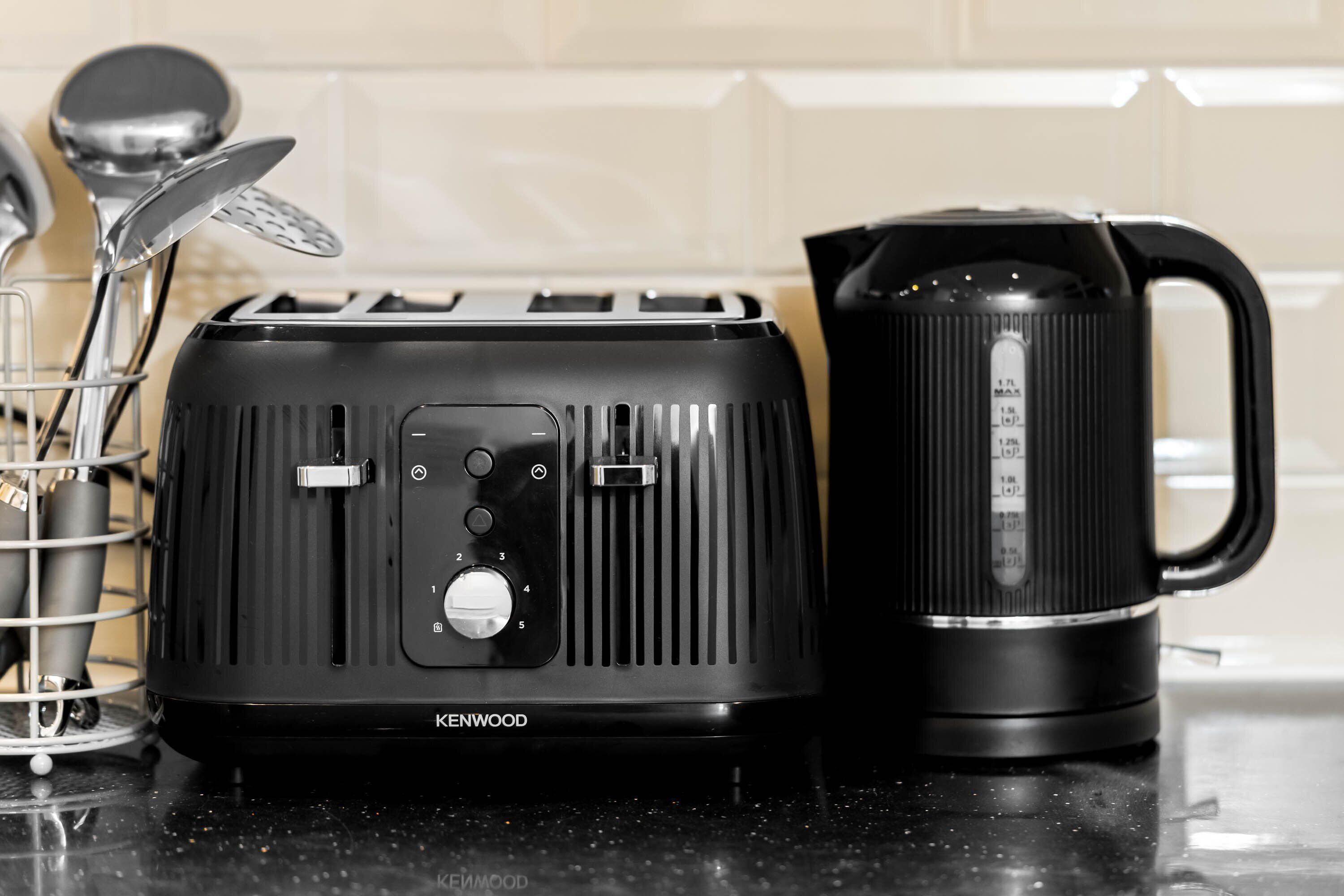 A Kenwood toaster and a black coffee maker on a kitchen counter.