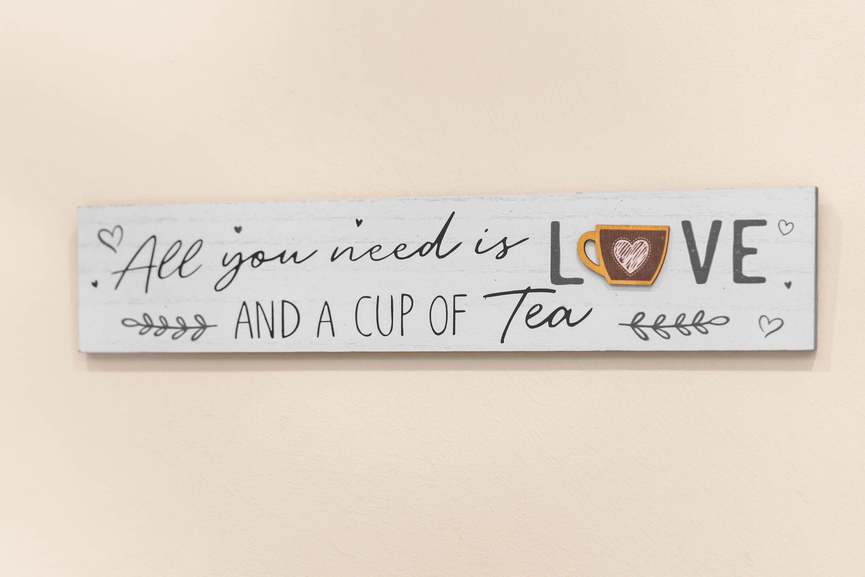 A decorative sign with the text "All you need is LOVE and a cup of Tea."