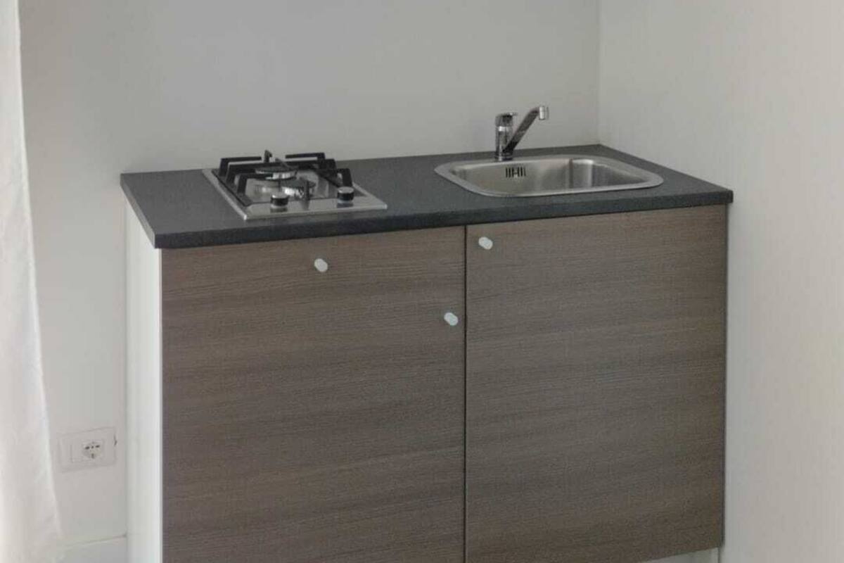 A compact kitchen with a built-in gas stove, a sink, and a dark countertop.