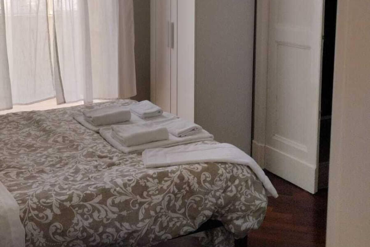 A bedroom with a bed, a wardrobe, and a door.