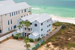 Un bâtiment situé sur la côte, doté de plusieurs étages, d’un balcon et offrant une vue sur l’océan.