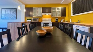 A modern kitchen with a central island, dark wooden table, and chairs. - 29SV-VE Newo Retro (Quebec)
