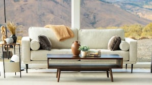 A living room with a sofa, coffee table, and decorative items.
