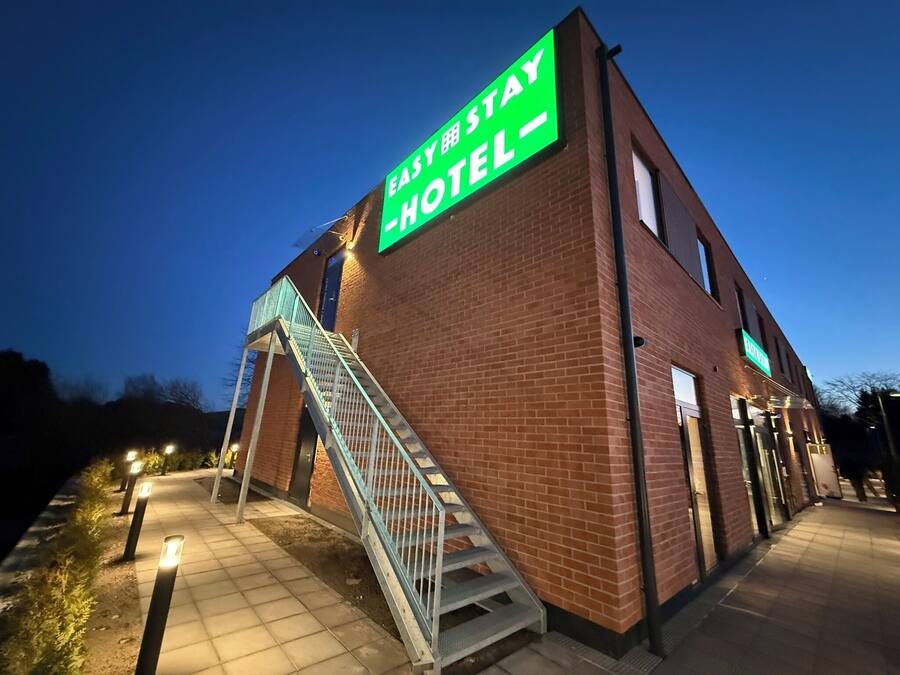 Un hotel con un llamativo letrero verde que dice "EASY STAY HOTEL".