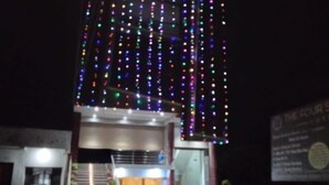 Un bâtiment avec un escalier menant à une porte, le tout entouré de lumières colorées.
