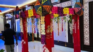 Une entrée décorée avec des compositions florales et des ornements suspendus.