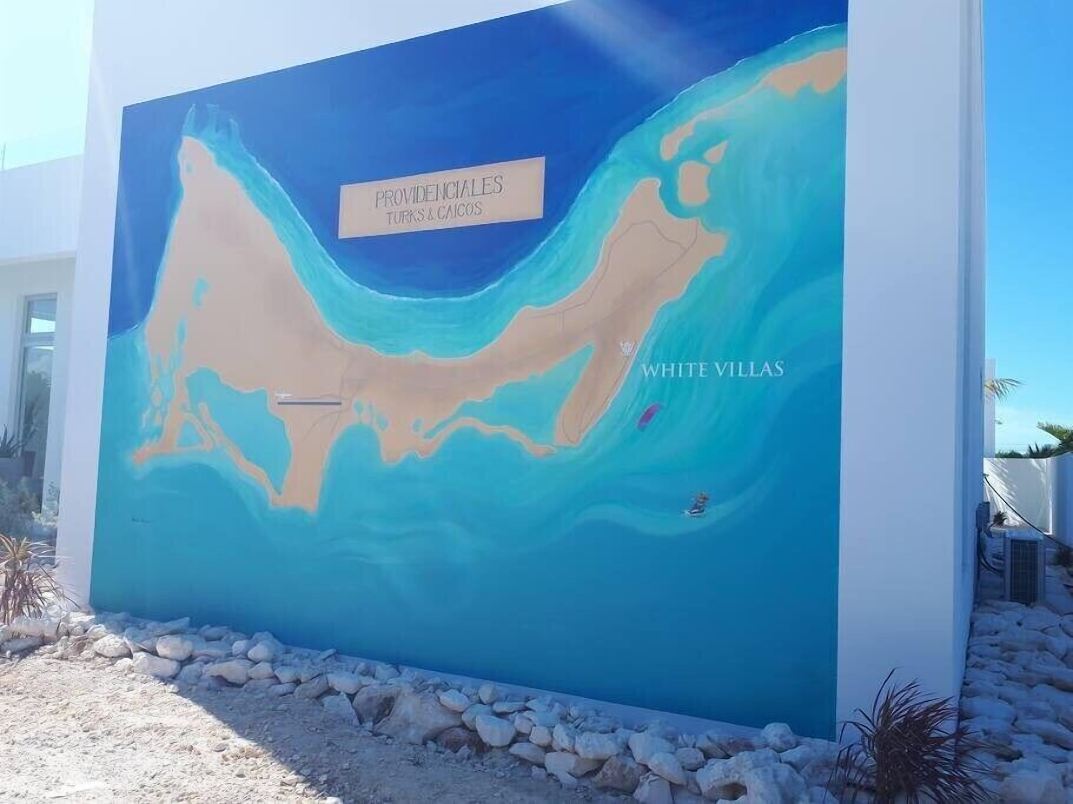 Une fresque représentant une zone côtière, avec les inscriptions « PROVIDENCIAS TURKS & CAICOS » et « WHITE VILLAS ».