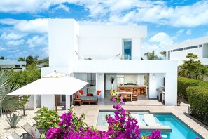 A modern two-story house with a pool, outdoor seating, and a dining area. - 2bdr Oceanside Vacation Villa, Hotel Amenities v3 (Providenciales)