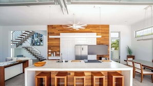 Una cocina moderna con una isla central, detalles de madera y una estufa integrada.