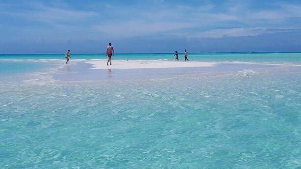 A beach scene with clear turquoise water and a sandy shore. - Family Beachside Villa With Hotel Amenities v7 (Providenciales)