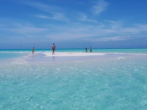 A beach scene with clear turquoise water and a sandy shore. - Family Beachside Villa With Hotel Amenities v7 (Providenciales)