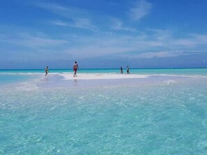 A beach with clear turquoise water and a sandy shore. - Family Oceanside Vacation Villa Hotel Amenities v8 (Providenciales)