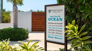 A sign for White Villas with a message about embracing the ocean and its beauty. - New Seaside Vacation Villa With Hotel Amenities v9 (Providenciales)