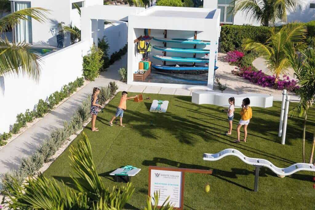 A modern building with a pool area, including a water slide and a weather station sign.