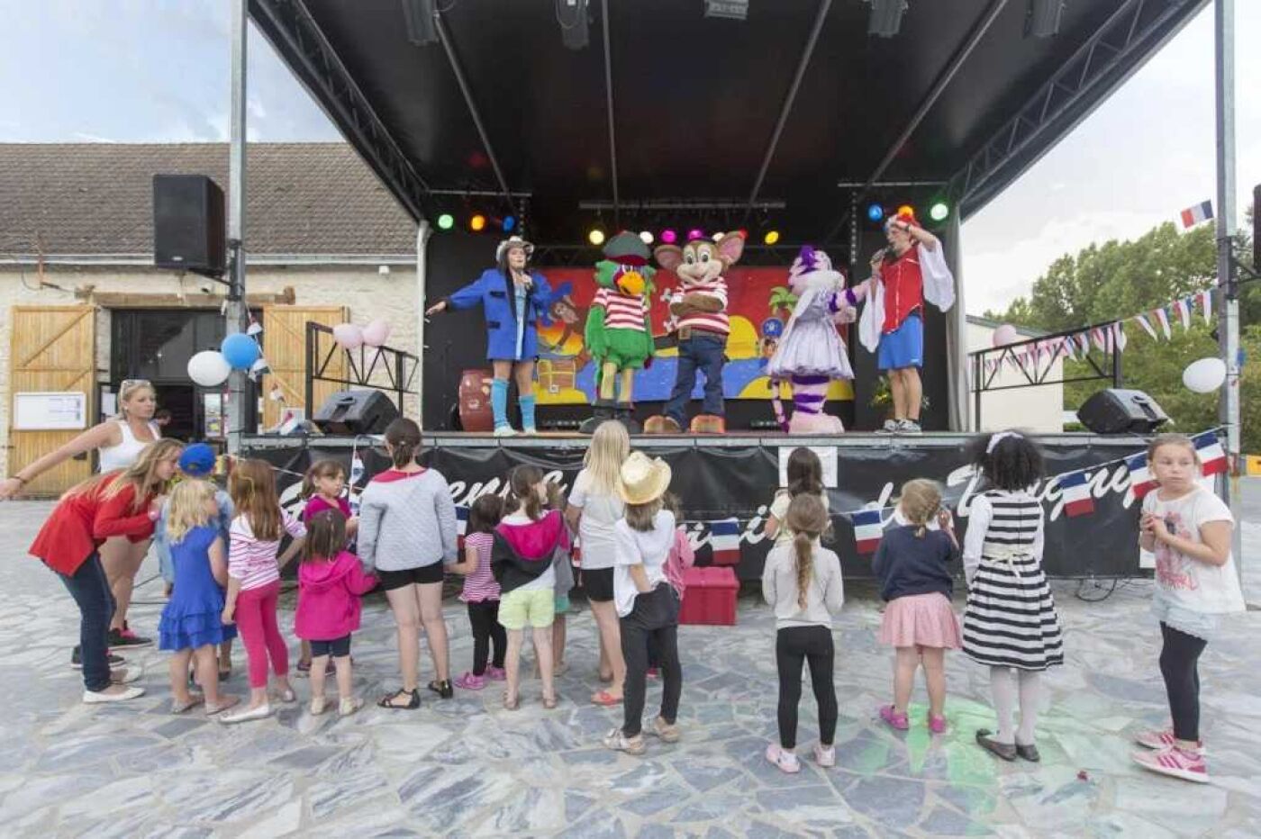 Un palco con artisti e bambini che guardano.